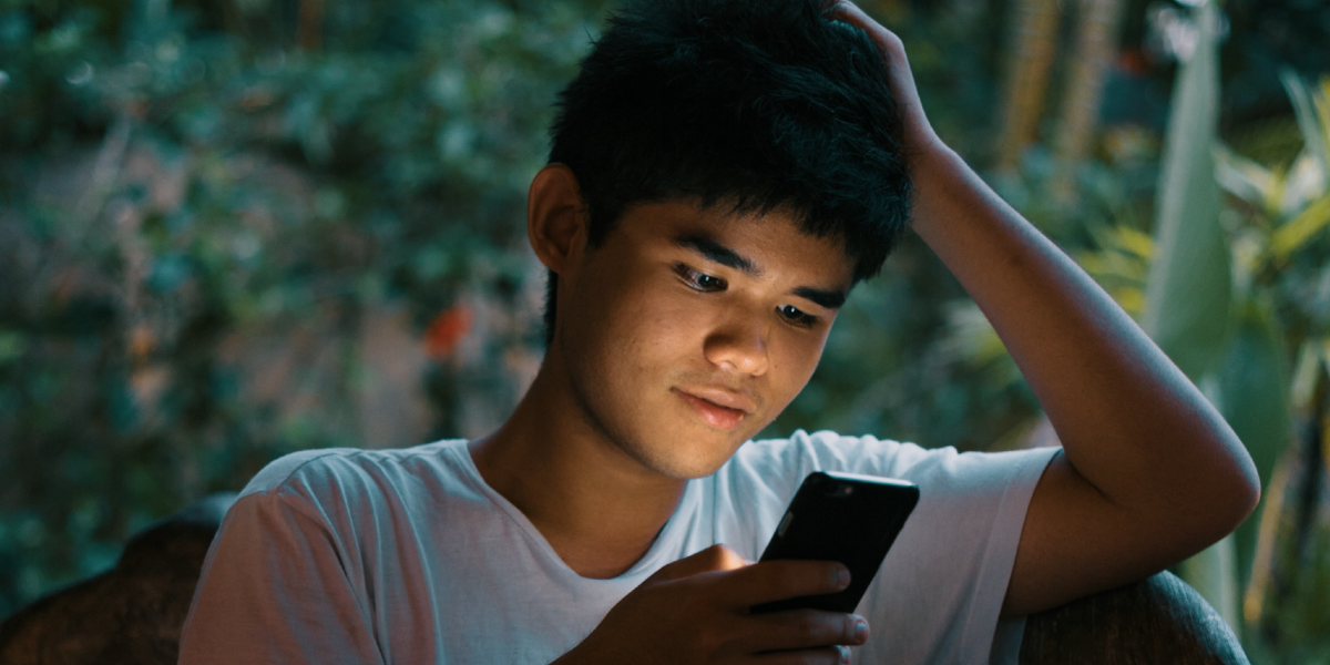 Adolescente revisa mensajes en su celular